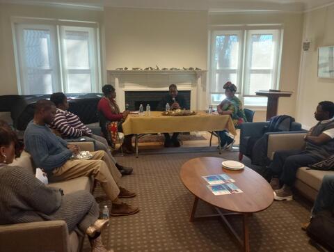 three people at table and audience members